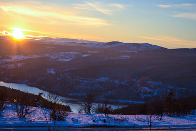 Scenic view of snowcapped mountains against sky during sunset