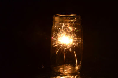 Close-up of illuminated lamp against black background