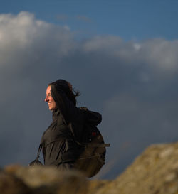 Side view of woman looking away against sky