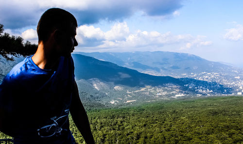 Young man using smart phone against sky