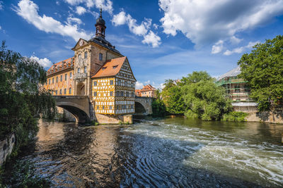 Arch bridge over river against buildings