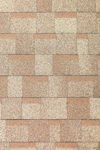 Background and texture of rectangular tiles of beige color of roofing bituminous tiles.