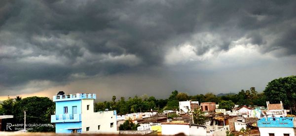 Buildings in city against cloudy sky