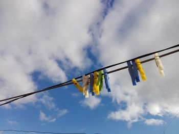 Low angle view of clothes hanging on clothesline against sky