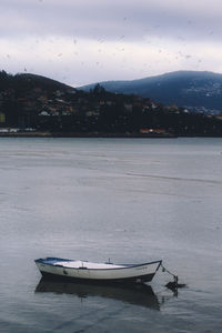 Boat moored in lake against sky