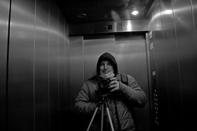 Young man photographing in illuminated camera