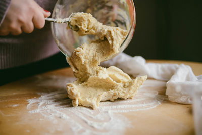 Cropped image of woman making dough 