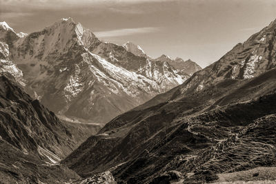 Colossal snowy mountains and deep valleys amid the himalayas, in nepal. black and white photo.