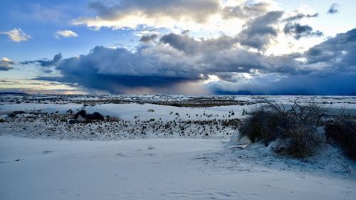 Scenic view of snow covered land against sky