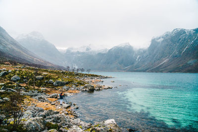 Scenic view of sea and mountains against sky