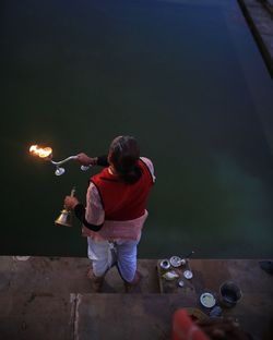 High angle view of pundit practicing religious rituals at lakeshore