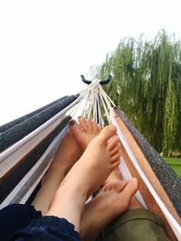 Close-up of man holding umbrella against sky