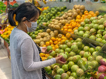 Full length of woman holding fruits at market