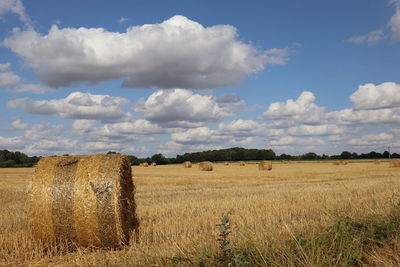 Hay bales on field against sky