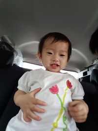 Low angle portrait of baby girl in car