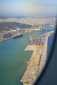 Aerial view of city by sea against sky