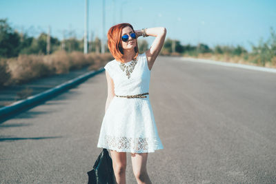 Woman wearing sunglasses standing on road