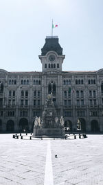 Statue in city against clear sky