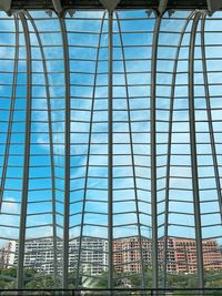 Low angle view of glass building against blue sky