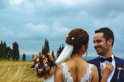 Young couple kissing against sky