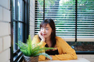 Close up of young pretty asian woman sitting in the cafe feeling relax.