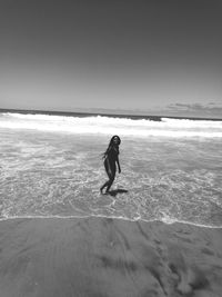 Full length of man on beach against sky beach.. life.. black and white.. love and peace 