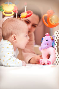 Portrait of cute baby girl sitting on sofa at home