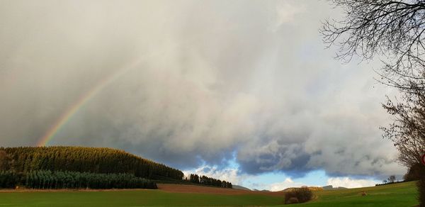 Scenic view of rainbow over land against sky