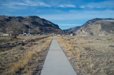 Footpath on field against mountains