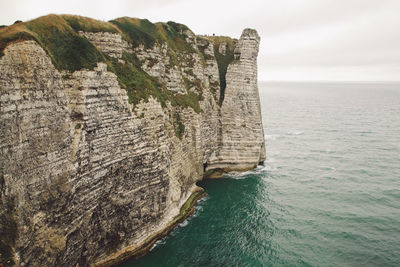 Rock formations by sea against sky