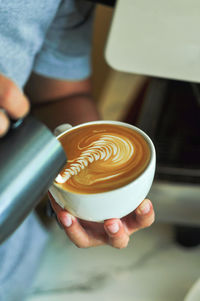 Cropped image of hand holding coffee cup