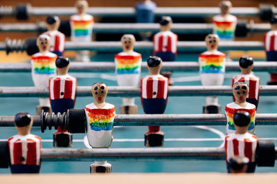 High angle of detail of retro table soccer with wooden miniature figurines of players on metal bars