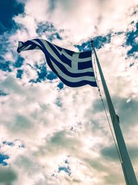 Low angle view of flag against cloudy sky