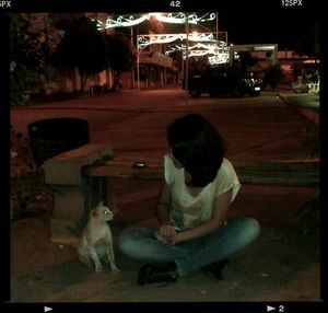 Rear view of woman sitting at night