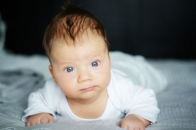 Portrait of cute baby boy lying on bed