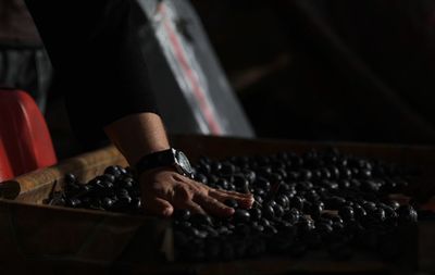 Midsection of woman touching olives