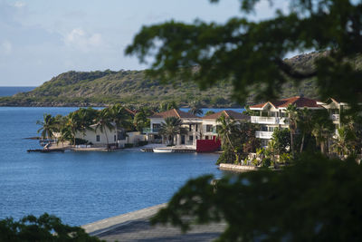 Buildings by sea against sky