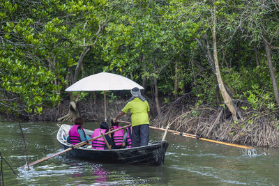 Boat in river amidst trees during rainy season