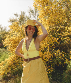 Young woman standing against trees