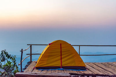 Tent on roof against sky at sunset