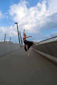 Woman with arms raised against sky