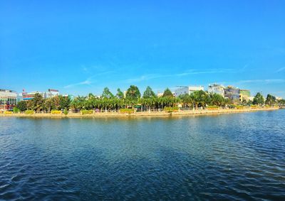 Scenic view of sea by building against blue sky