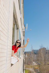 Woman waving hand through window