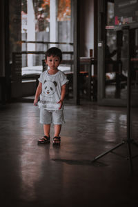 Full length portrait of cute boy standing on floor