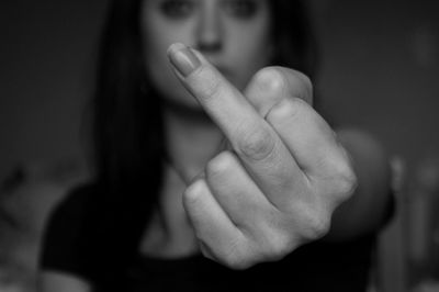 Close-up of woman showing middle finger