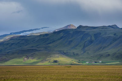 Scenic view of field and mountains against sky