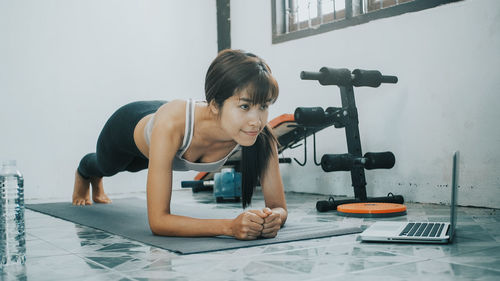 Full length of woman exercising at home