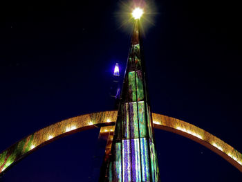 Low angle view of illuminated tower against sky at night