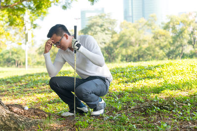 Rear view of man playing at golf course