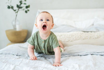 Cute baby boy sleeping on bed at home